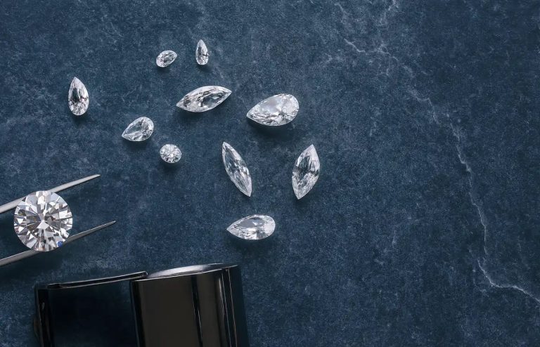 Ekte diamanter i ulike slipformer på lys lilla bakgrunn – illustrerer hvordan man kan se om en diamant er ekte.