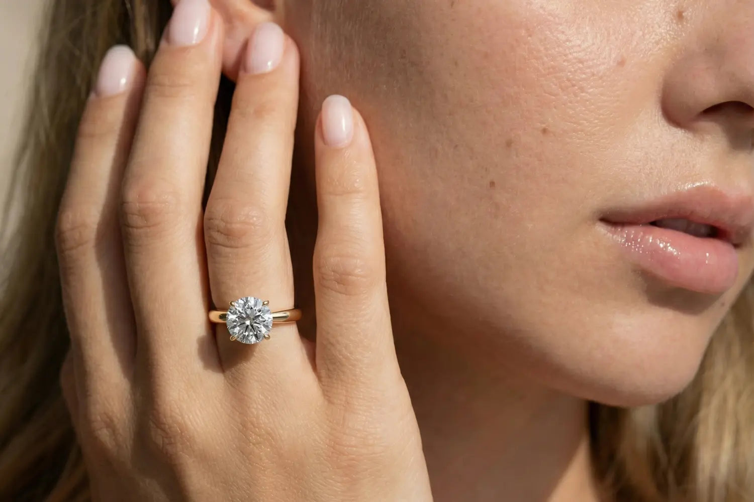 Forlovelsesring dame i gult gull med rund lab diamant vist på hånd