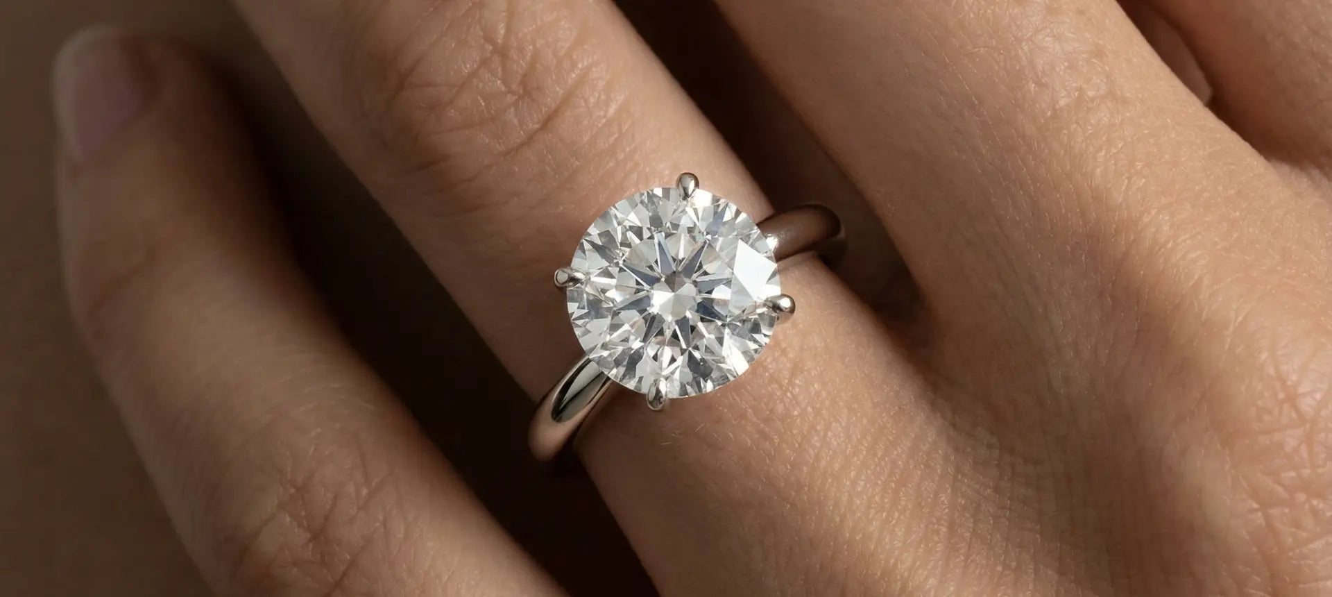 Hva burde en forlovelsesring koste - hånd med diamantring som viser forlovelsesring budsjett
