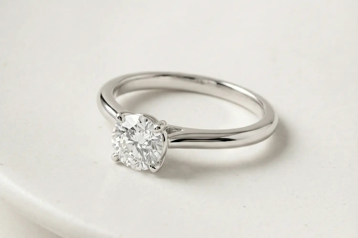 Rund lab diamant ring i hvitt gull – nærbilde på lys steinoverflate