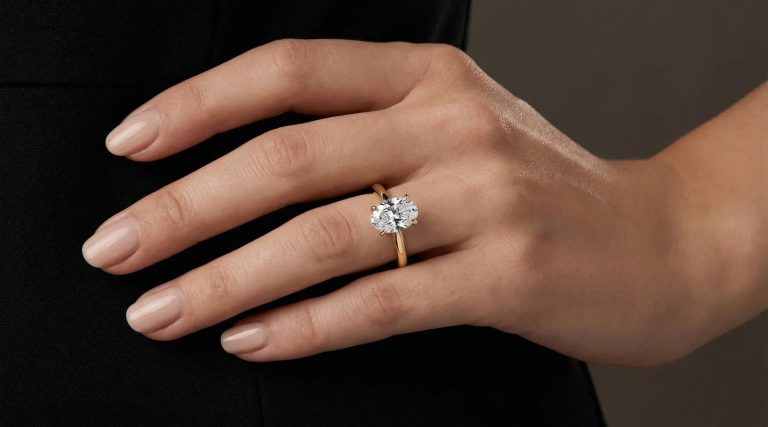 Lab diamant vs naturlig diamant – forlovelsesring i gult gull med oval briljant på hånd