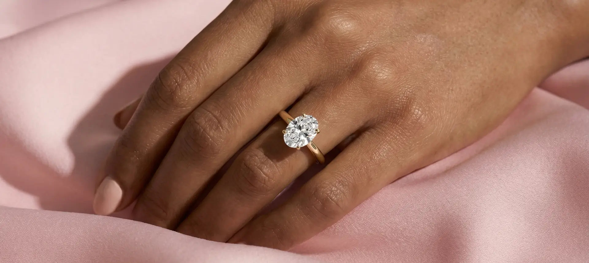 Oval diamant i klassisk enstensinnfatning av hvitt gull. Illustrerer hvordan ovale diamanter gir størrelsesillusjon og elegant form
